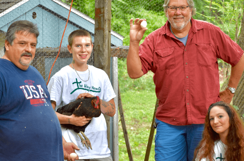 Way Homes founder Greg Anderson and overseer, Larry Shortt with two residents, in front of our chicken coop